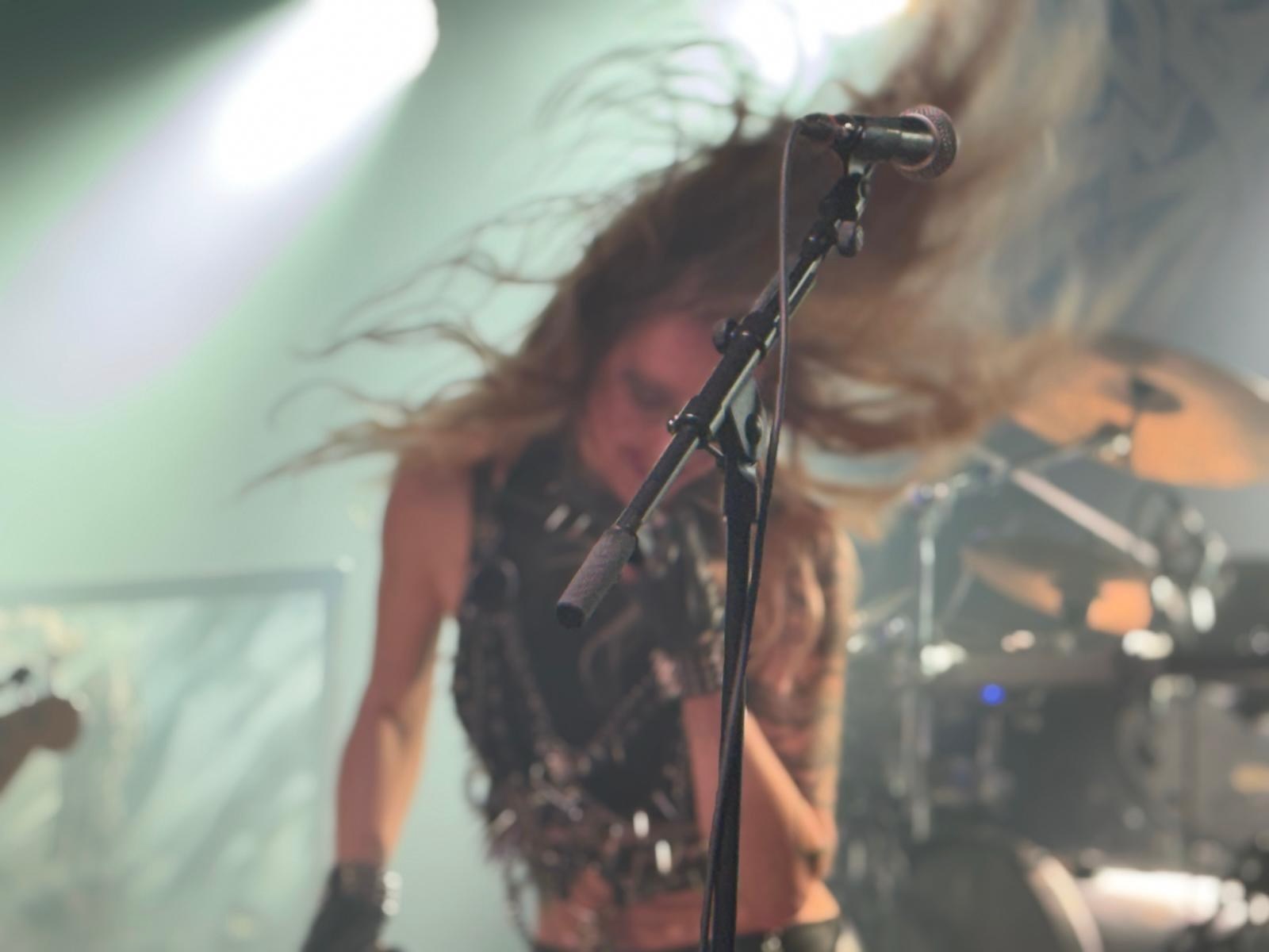 Die Sängerin Laura Guldemond tanzt vor ihrem Mikro und schüttelt ihre langen Haare